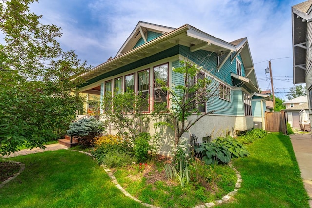 view of side of home with a yard