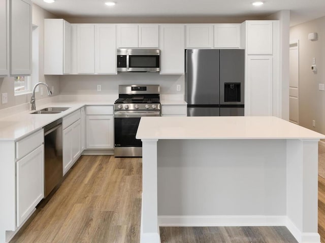 kitchen featuring appliances with stainless steel finishes, white cabinetry, and sink