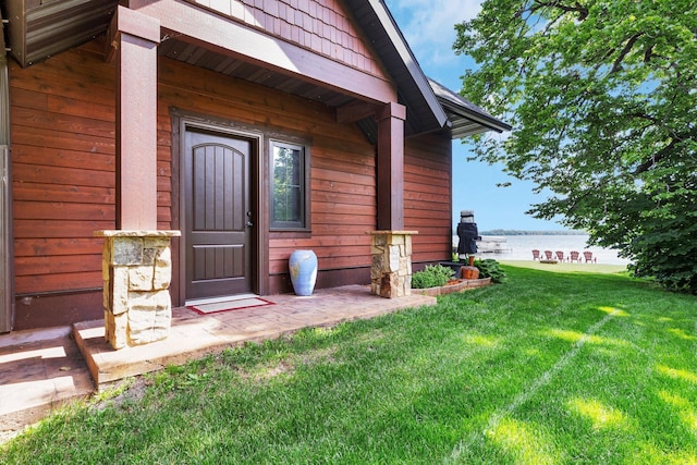 property entrance featuring a lawn