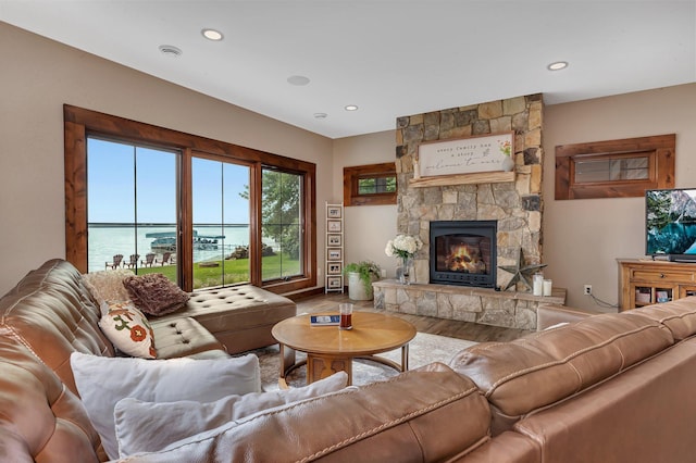 living room with a fireplace, a water view, and wood-type flooring