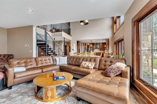 living room featuring a towering ceiling and light hardwood / wood-style floors