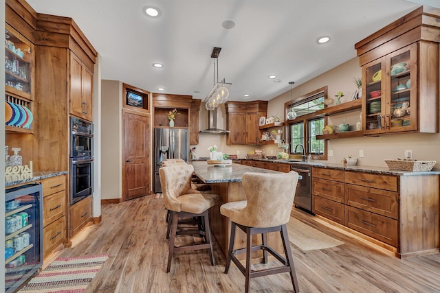 kitchen with sink, stainless steel appliances, beverage cooler, wall chimney range hood, and light hardwood / wood-style flooring