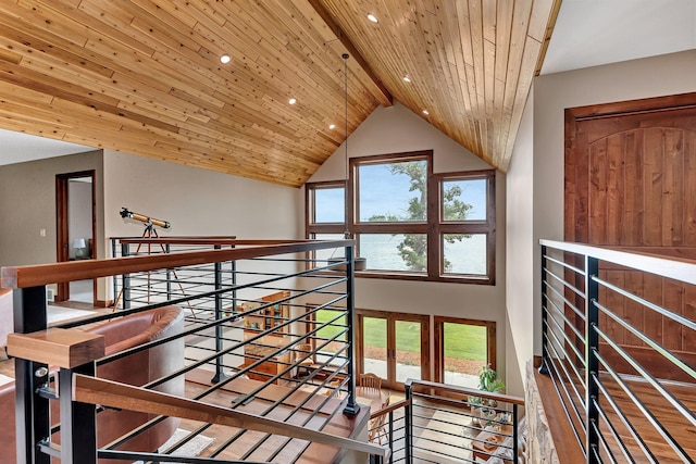 corridor with a wealth of natural light, beamed ceiling, wooden ceiling, and high vaulted ceiling