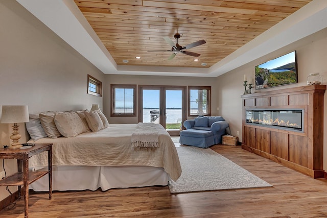 bedroom featuring ceiling fan, wooden ceiling, and a tray ceiling