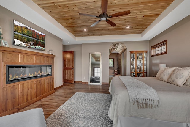 bedroom featuring a raised ceiling, wooden ceiling, and hardwood / wood-style flooring