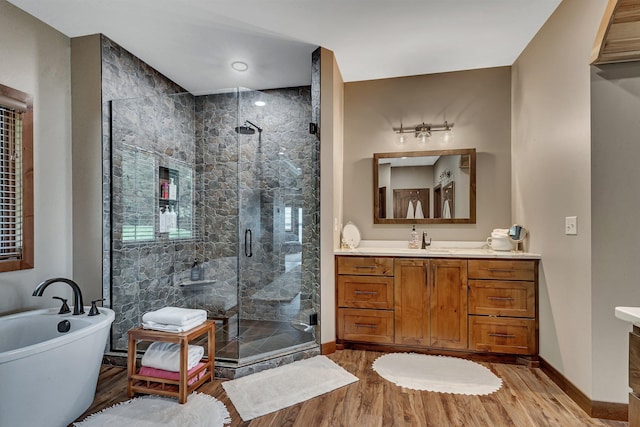 bathroom with hardwood / wood-style floors, vanity, and independent shower and bath