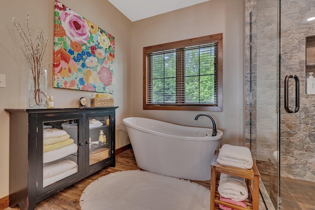 bathroom featuring hardwood / wood-style flooring and a tub to relax in