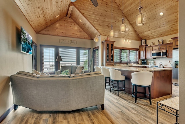 living room featuring light hardwood / wood-style flooring, high vaulted ceiling, wooden ceiling, and beamed ceiling