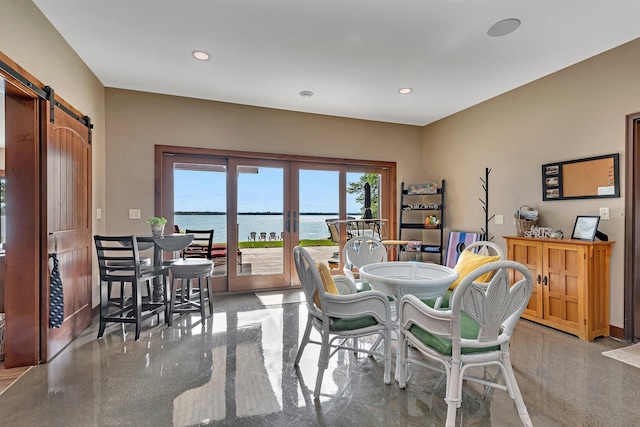 dining room with a barn door and a water view