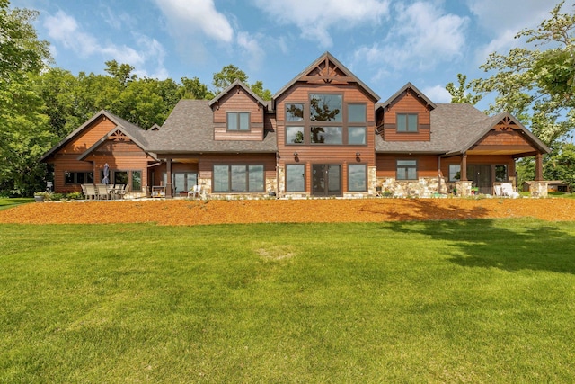 view of front of house with roof with shingles and a front yard