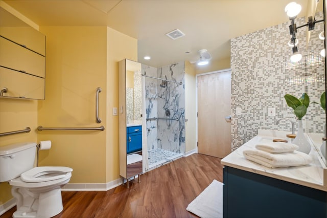 full bath featuring vanity, wood finished floors, a walk in shower, and toilet