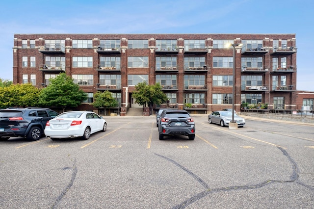 view of apartment building / complex featuring uncovered parking