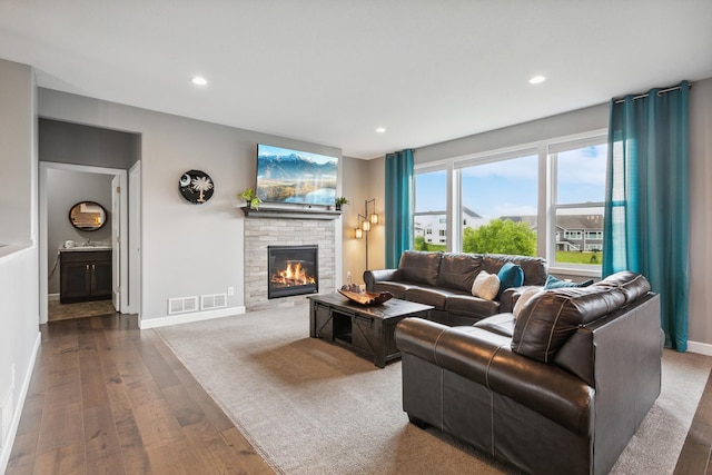 living room featuring a fireplace, hardwood / wood-style floors, and sink