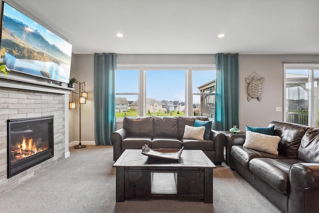 carpeted living room featuring plenty of natural light and a brick fireplace