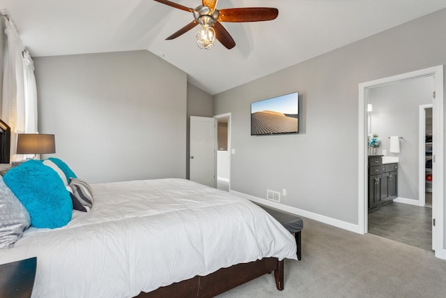 carpeted bedroom featuring ceiling fan, ensuite bathroom, and vaulted ceiling