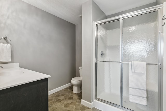 bathroom with toilet, an enclosed shower, a textured ceiling, and vanity