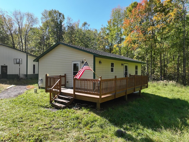 back of property featuring a wooden deck and a yard