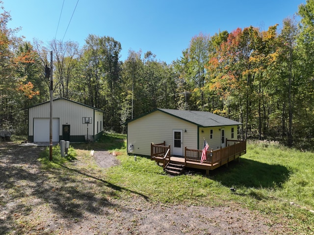 rear view of house with an outbuilding, a garage, and a wooden deck