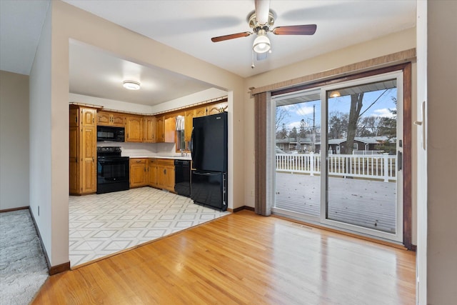 kitchen with light hardwood / wood-style floors, ceiling fan, and black appliances