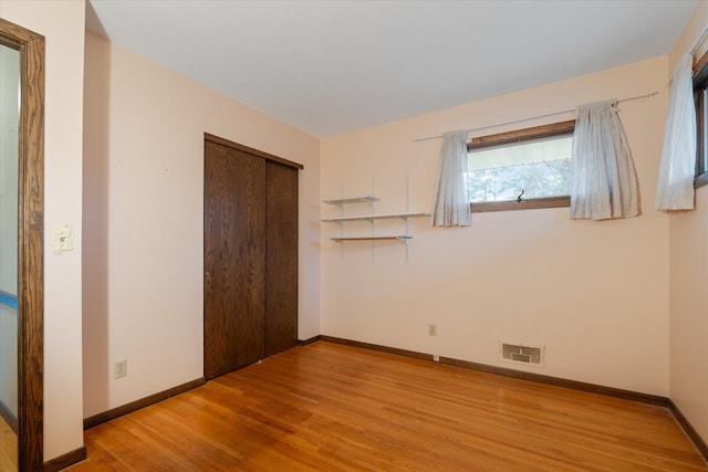 unfurnished bedroom with light hardwood / wood-style flooring and a closet