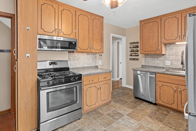 kitchen with ceiling fan, appliances with stainless steel finishes, sink, and decorative backsplash