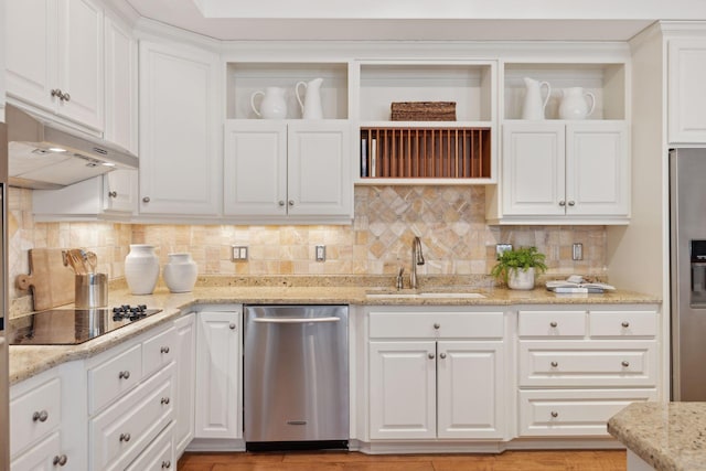 kitchen featuring light stone counters, stainless steel appliances, white cabinets, a sink, and under cabinet range hood