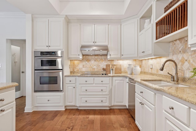 kitchen with stainless steel appliances, a sink, white cabinets, and under cabinet range hood