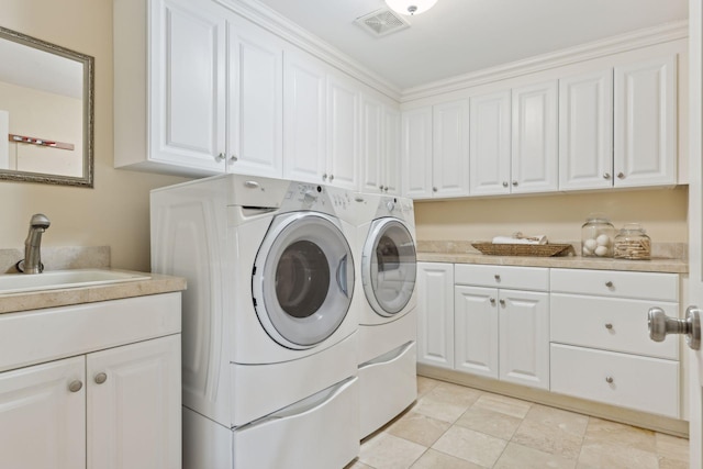 laundry room featuring a sink, visible vents, washing machine and clothes dryer, and cabinet space