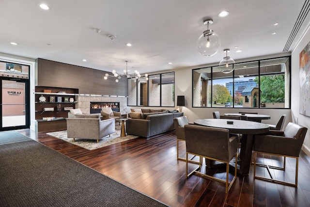 interior space with recessed lighting, a fireplace, dark wood finished floors, and a notable chandelier