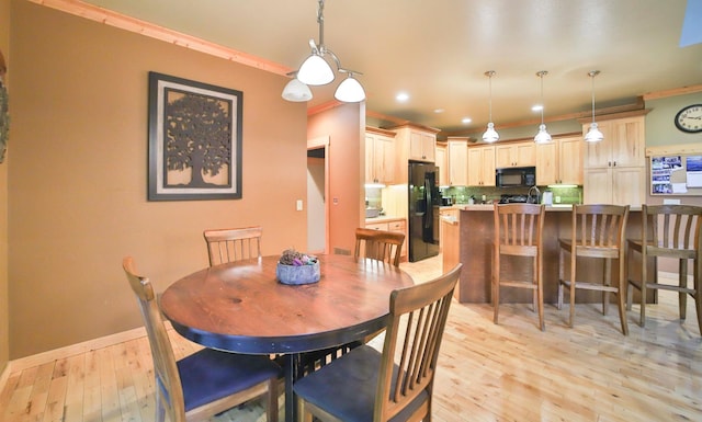 dining room featuring light hardwood / wood-style floors and crown molding