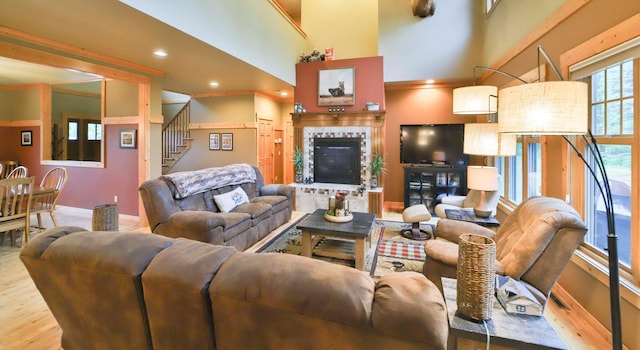 living room featuring wood-type flooring, a fireplace, and a towering ceiling