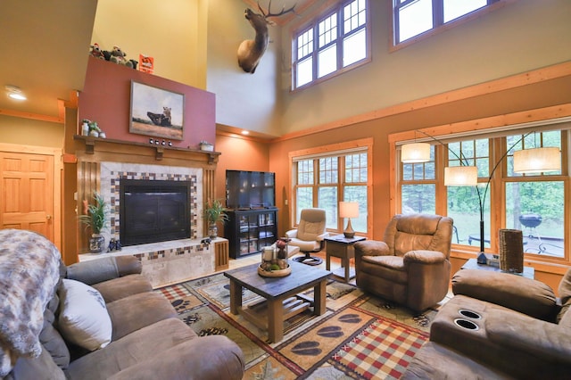 living room featuring a fireplace, plenty of natural light, and a high ceiling