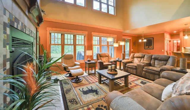 living room featuring a fireplace, a towering ceiling, and a notable chandelier