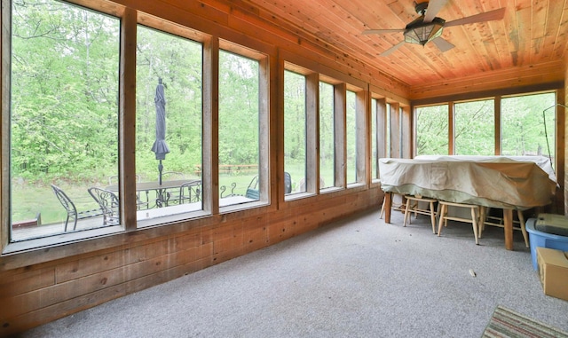 sunroom with ceiling fan and wooden ceiling