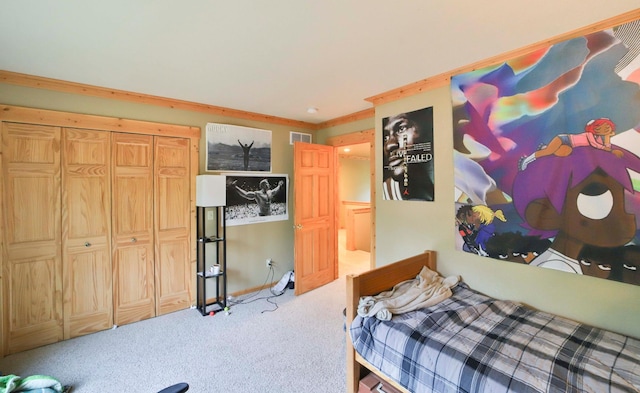 carpeted bedroom with ornamental molding and a closet