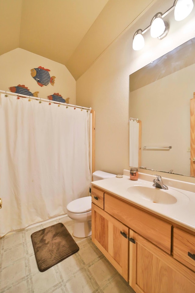 bathroom featuring vanity, vaulted ceiling, and toilet