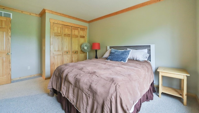 carpeted bedroom featuring crown molding and a closet