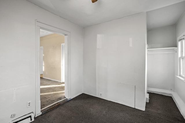 spare room with dark colored carpet