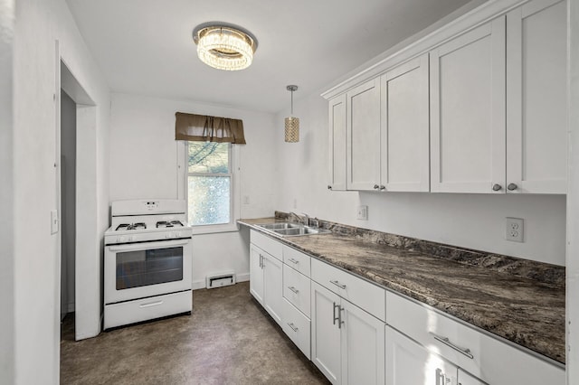 kitchen featuring sink, dark stone countertops, decorative light fixtures, white cabinetry, and white range with gas cooktop