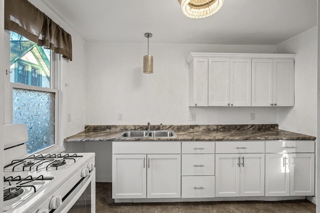 kitchen with white gas stove, sink, white cabinets, and decorative light fixtures