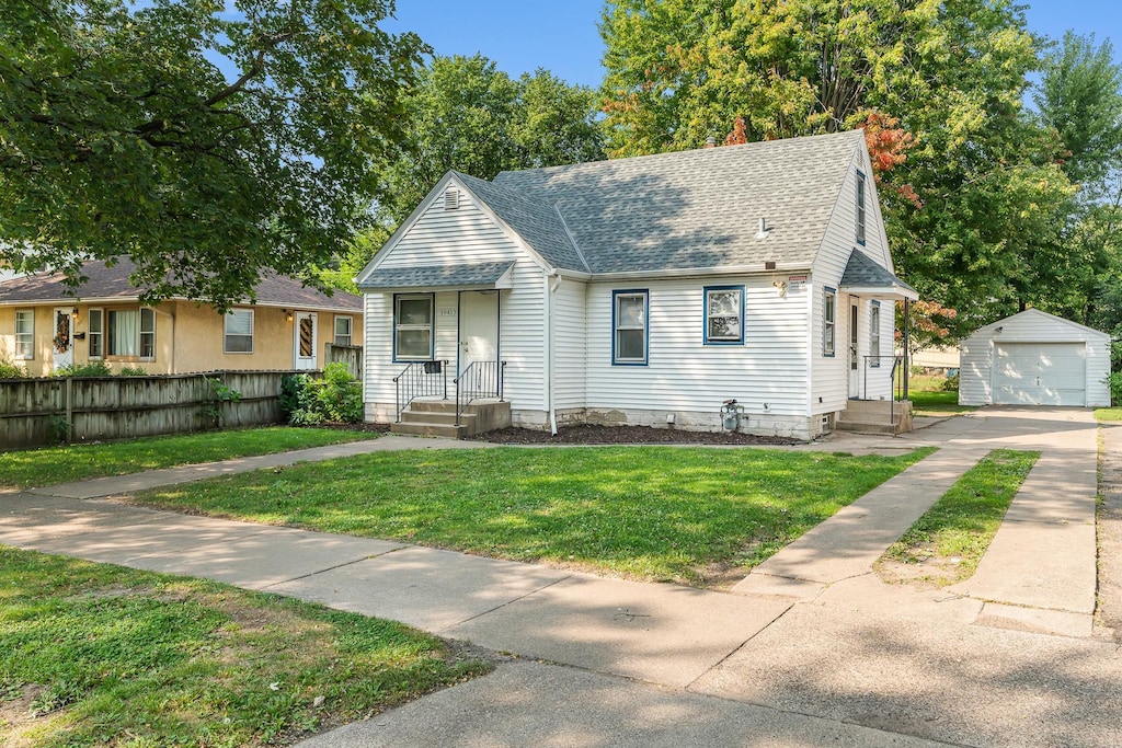 view of front of property featuring a front lawn, an outdoor structure, and a garage