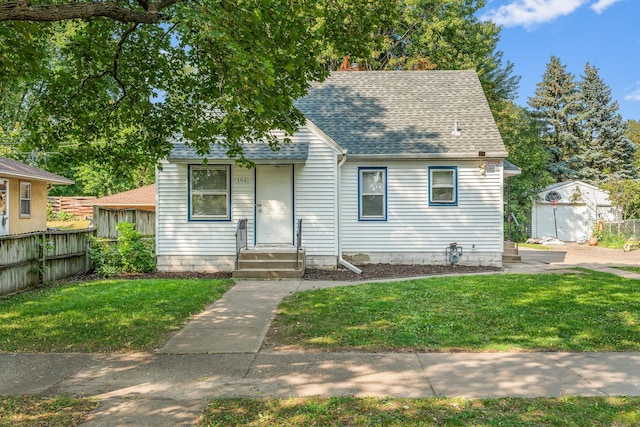 view of front of property featuring a front yard and an outbuilding