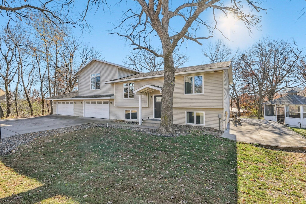 raised ranch featuring a front lawn and a garage