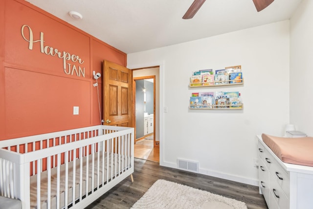 bedroom featuring ceiling fan, dark wood-type flooring, and a nursery area