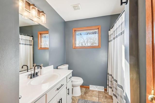 bathroom with tile patterned flooring, vanity, and toilet