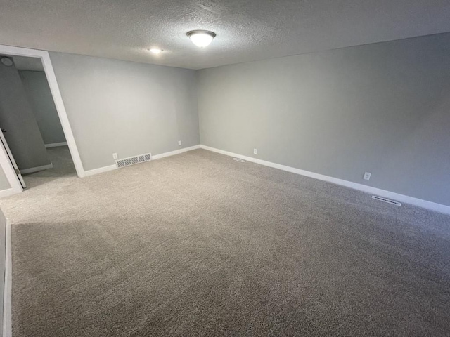 spare room featuring carpet flooring and a textured ceiling