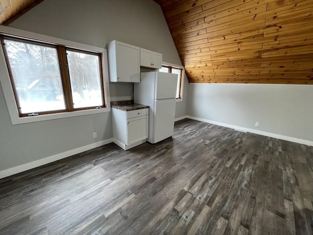 interior space featuring dark wood-type flooring, wooden ceiling, white fridge, white cabinetry, and lofted ceiling