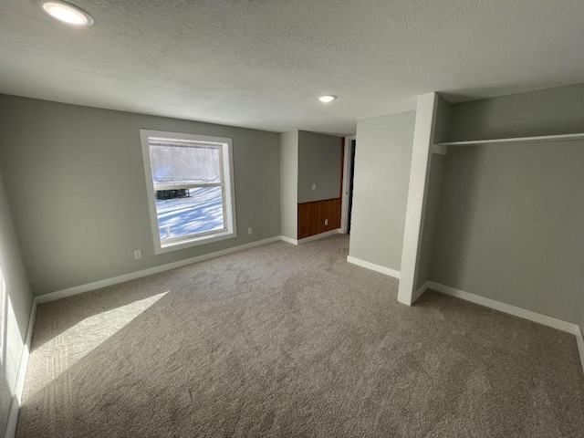 unfurnished bedroom with carpet flooring, a textured ceiling, and a closet