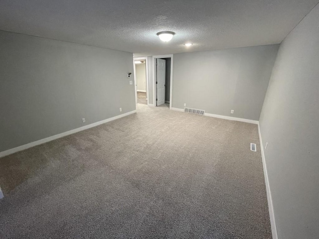 empty room with carpet flooring and a textured ceiling