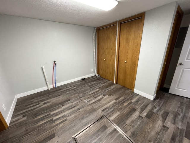 unfurnished bedroom featuring dark hardwood / wood-style flooring and a textured ceiling